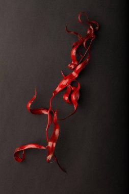 Red leaves on a black background. Red and black creative creative wallpaper. Texture for design.