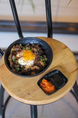Biftek ve yumurtalı pilav bir restorandaki ahşap masada.