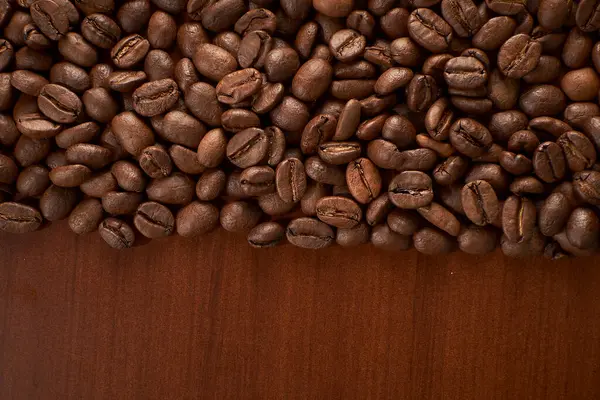 brown roasted beans on a brown wooden background