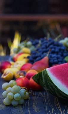                                 Tahtaya üzüm ve çeşitli meyveler serpilmiştir. 