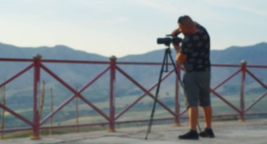                                Bokeh, kameralı bir adamı tripoda çekti.