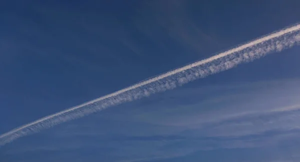 空に飛行機のトレイルを持つ雲の長い行列 — ストック写真