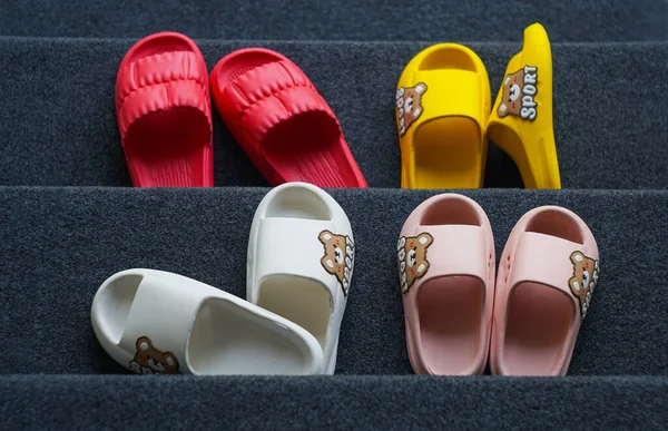 Different types of rubber shoes stand on the carpet
