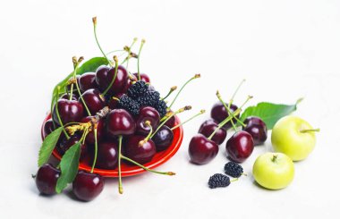                                   Beyaz arka planda kırmızı kirazlar var.