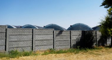                               Seranın çatısı beton duvarın arkasında görünür. 