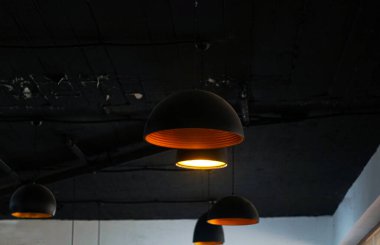                                Tavanda siyah fenerler asılı, ışıklar yanıyor.