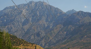                                Dağların arasından büyük bir elektrik hattı görünüyor.