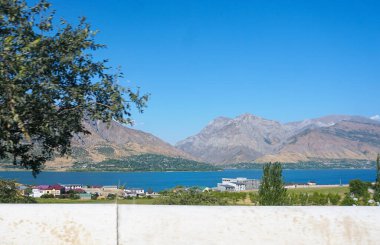                                 Yol boyunca ağaçlar ve dağlar görülebilir mavi gökyüzü