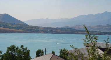                               Suyun kenarında dağlar ve evler var. 