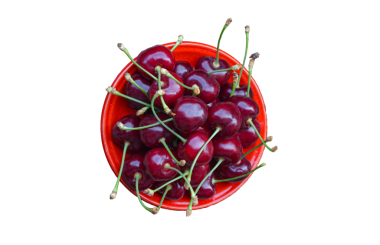 Beyaz arka planda bir kasede kırmızı kirazlar var.