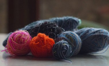                                    Pencerenin önünde bir sıra renkli yün iplik duruyor..   