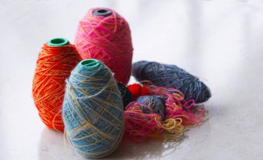                                 Pencerenin önünde bir sıra renkli yün iplik duruyor..