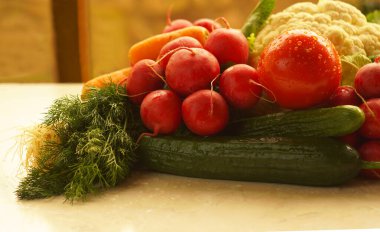                                                             Domates, salatalık, pencerenin önündeki masada çeşitli sebzeler.  