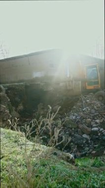 Bir kazıcı hasarlı alandaki bir kamyona çakıl taşlarını yüklüyor.