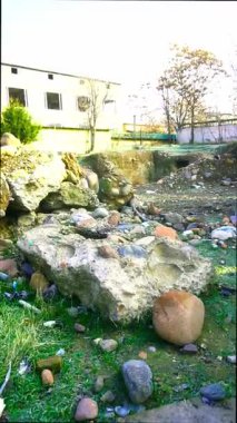 Bir kazıcı hasarlı alandaki bir kamyona çakıl taşlarını yüklüyor.