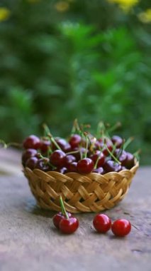 Kirazlar dışarıda bir sepette duruyor.