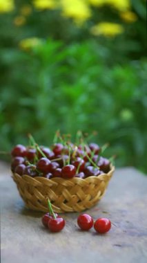 Kirazlar dışarıda bir sepette duruyor.