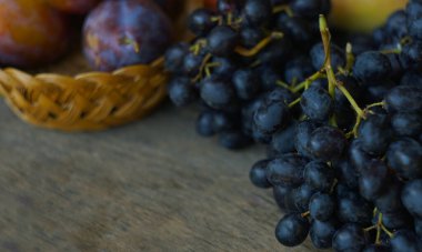                                                               Siyah üzümler ve çeşitli meyveler pencerenin önündeki tahtaya saçılmıştır.