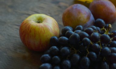                 Tahtada siyah üzüm, sarı yapraklar ve çeşitli meyveler vardır.    