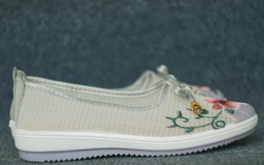                  Halıda çiçek desenli kız ayakkabıları var..              