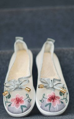                                Halıda çiçek desenli kız ayakkabıları var..