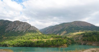                               Yazın, gün ışığı nehrin yanındaki yeşil dağa düşer.. 