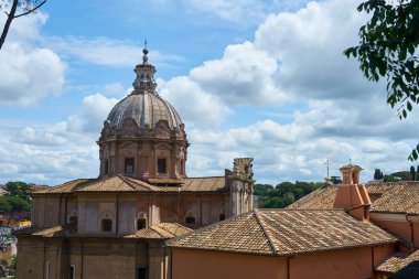 Bulutlu bir gökyüzünün arka planında antik bir Roma binasının kubbesi.