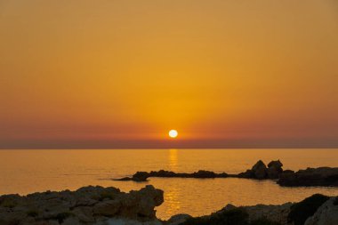 Akdeniz 'in taş kıyıları gün batımında