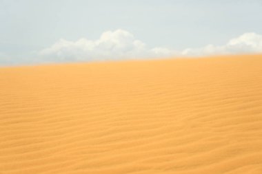 Çölde kum tepeciği, arkasında bulutlar.