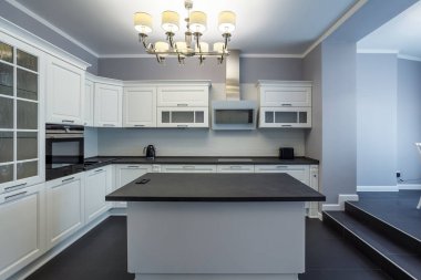 Fashionable kitchen with grey walls and white furniture, a kitchen in a modern classic style with granite countertop and bar rack
