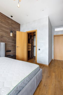 Büyük, modern yatak odası. Yatak başlıklı ahşap kaplamalı duvarlar