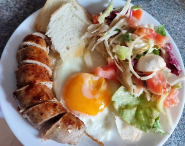 Bir tabakta yumurta, salata ve sosis ile çırpılmış yumurta, lezzetli yiyeceklerin yakın çekimi, lezzetli bir kızarmış yumurtaya yakın plan