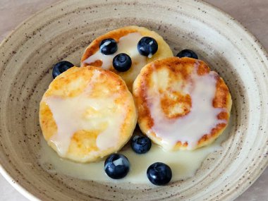 süzme peynirli krep, yoğunlaştırılmış süt ve yaban mersinli börek. Yakın plan. Kahvaltı.