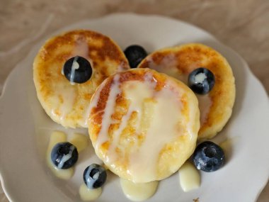süzme peynirli krep, yoğunlaştırılmış süt ve yaban mersinli börek. Yakın plan. Kahvaltı.