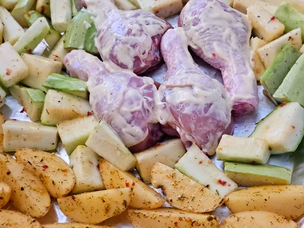 Fırında pişirmek için patates ve baharatlı çiğ tavuk eti. Lezzetli yiyeceklerin yakın çekimi.