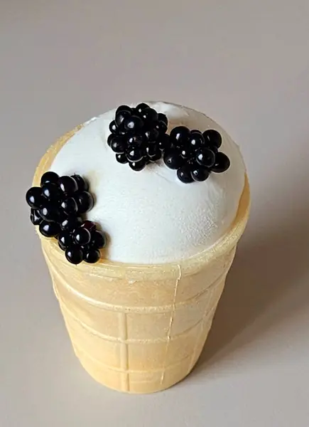 ice cream sundae in a waffle cup with blackberries on a gray background. Ice cream close up