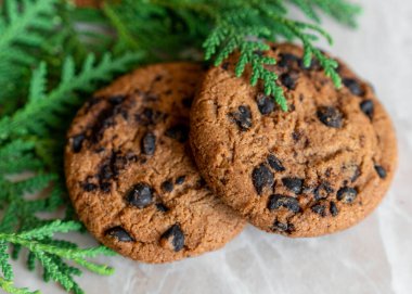 Masada nefis çikolatalı kurabiyeler var. Yakındaki firavun dalları ve kurabiyeler. Masadaki çikolatalı yulaflı kurabiyeler..