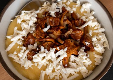 Masanın üstünde brynza ve mantarla servis edilen lezzetli bir banosh. Geleneksel Ukrayna yemeği