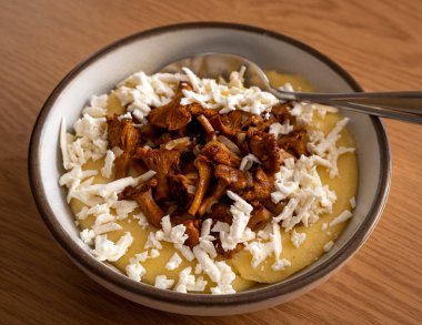 Masanın üstünde brynza ve mantarla servis edilen lezzetli bir banosh. Geleneksel Ukrayna yemeği