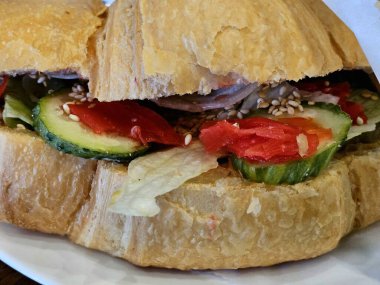 Kahvaltıda somonlu kruvasan, yumuşak peynir ve salata. Sebzeli, tavuklu, zencefilli ve susamlı kruvasan. Kruvasan sandviçi, yemek yakın plan.