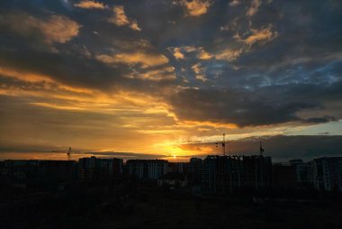 Şehrin üzerinde güzel bir günbatımı. Gün batımında renkli bulutlar. Şehrin üzerinde gün batımı