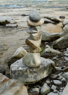 Nehir yatağının yanındaki kulelere yerleştirilmiş taşlar, dengeli taşlar, nehirdeki çakıl taşları, dağlardaki nehirdeki taş piramitler.
