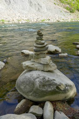 Nehir yatağının yanındaki kulelere yerleştirilmiş taşlar, dengeli taşlar, nehirdeki çakıl taşları, dağlardaki nehirdeki taş piramitler.