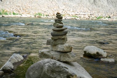 Nehir yatağının yanındaki kulelere yerleştirilmiş taşlar, dengeli taşlar, nehirdeki çakıl taşları, dağlardaki nehirdeki taş piramitler.