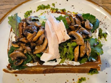 Tavuk filetosu, mantar ve roka ile Belçika waffle 'ı. Belçika yemeği. Yukarıdan görüntüle.