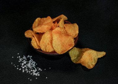 Kil kasedeki patates cipsi siyah arka planda izole edilmiş - büfe ya da bar menüsü. Siyah arka planda patates cipsi. Üst görünüm