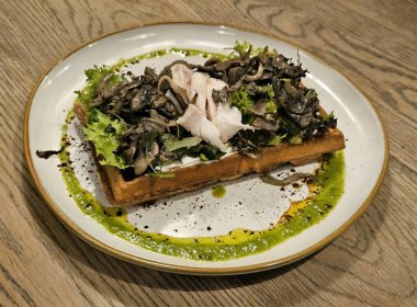 Mantarlı Belçika waffle 'ı, sous vide tavuğu ve marul. Güzel bir restoran sunumu. Yakın plan.