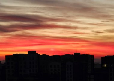 Kızıl günbatımı gökyüzü, akşamları kuzeyde yerleşim bölgesi üzerinde çok dramatiktir. Canlı renkli bulutlarla gün batımı gökyüzü. İvano-Frankivsk, Ukrayna 'dan gelen alacakaranlıkta parlak kırmızı gökyüzü.