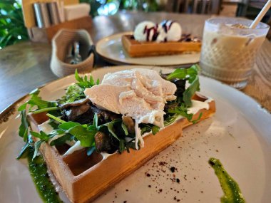 Soslu tavuk, kızarmış mantar ve otlu Belçika waffleları, yakın plan lezzetli yiyecekler.
