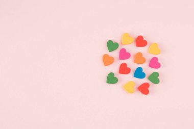 Pembe arka planda farklı renkte kalplerden oluşan bir bulut. Kopyalama alanı ile minimalist kavram